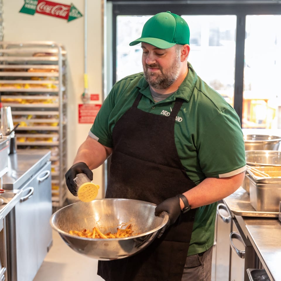Team member preparing fries in the restaurant kitchen