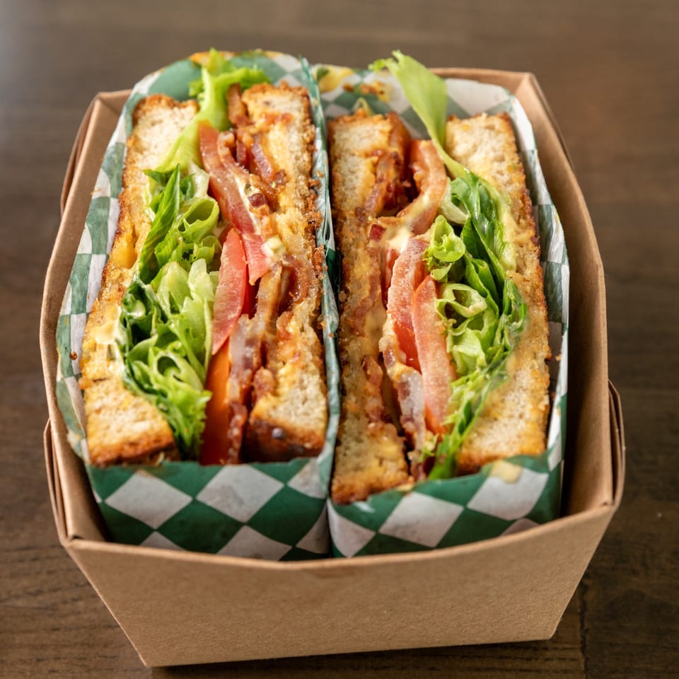 BLT sandwich halves in a takeaway tray